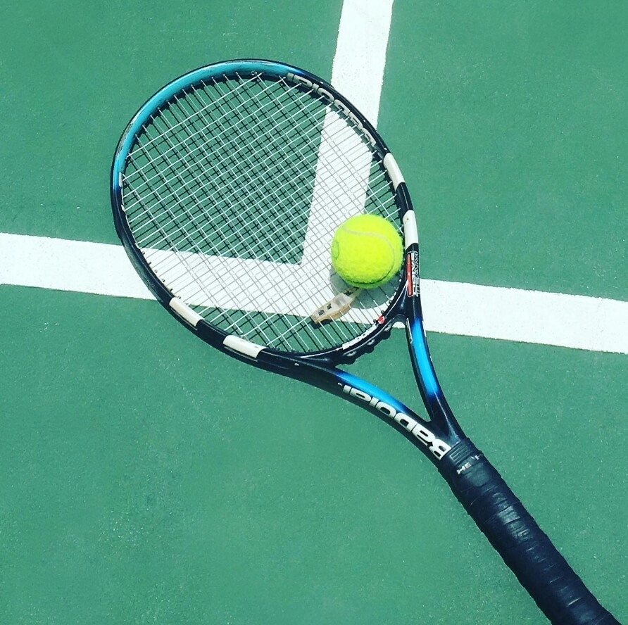 Tennis racket and ball on court